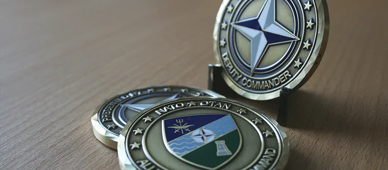 individuell geprägter NATO Coin mit kolorierten Logos im Coinholder aufgestellt